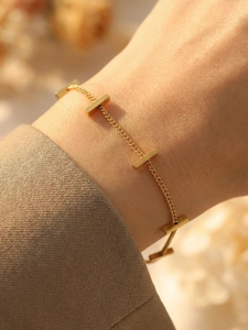 Detail of minimalist 18K gold bamboo link bracelet showing fine craftsmanship on wrist