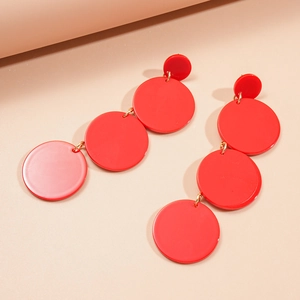Detail of red geometric acrylic drop earrings with four cascading round discs and gold links
