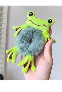 Close-up of cute green plush frog hair scrunchie with soft grey faux fur texture