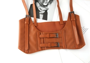 Detail of brown PU leather corset belt vest featuring adjustable straps and metal buckles