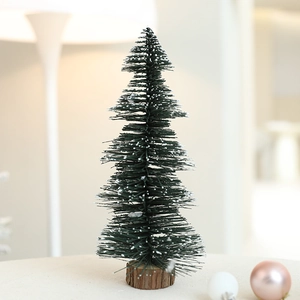 Mini tabletop Christmas tree with white snow flocking on a natural round wooden base