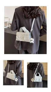Vue détaillée du sac à bandoulière gris clair avec design revers et breloque peluche