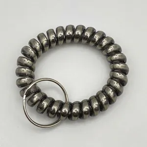 Close-up of a matte dark grey spiral phone cord keychain with a silver metal ring connector