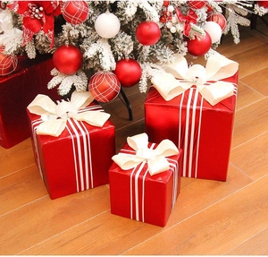 Tre scatole regalo di Natale a strisce rosse e bianche con fiocchi beige