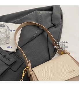 Detail of beige textured fabric handbag with gold buckle and fashion leather stamp