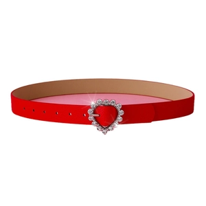 Red leather heart belt with sparkling rhinestone buckle on a minimalist white background