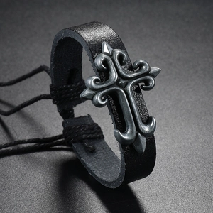 Macro view of adjustable woven leather bracelet featuring a vintage silver cross detail