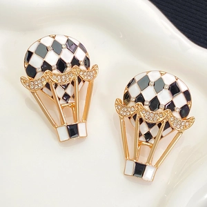 Détail de la boucle d'oreille montgolfière en damier avec cadre doré et strass micro-incrustés