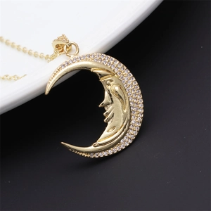 Detailed macro shot of a gold moon face pendant with sparkling micro-pave cubic zirconia