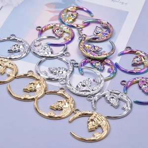 Macro shot of crescent moon and skull pendants in gold, silver, and rainbow steel