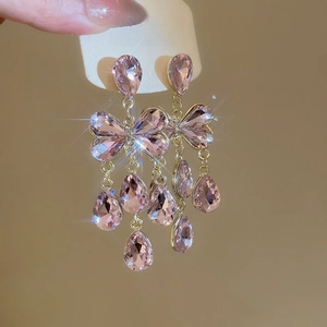 Detail of pink crystal butterfly earrings with water drop tassels on a display card