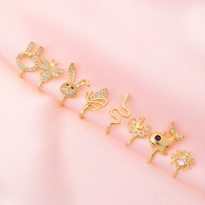 Macro shot of gold-plated animal nose clips with zircons on pink silk background