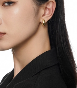 Close-up of a model wearing small golden hammered texture S925 silver hoop earrings