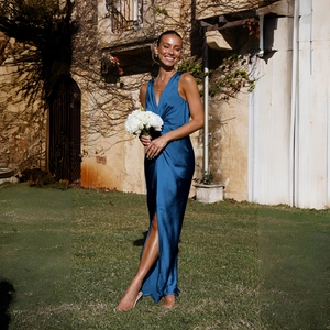 Gros plan d'une élégante robe de soirée en satin bleu foncé avec col en V et fente haute
