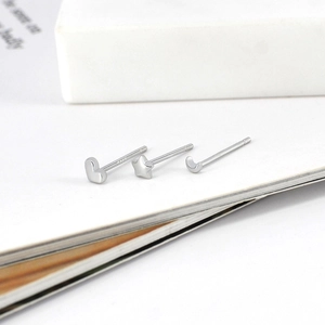 Macro view of S925 silver heart, star, and crescent moon stud earrings set on book