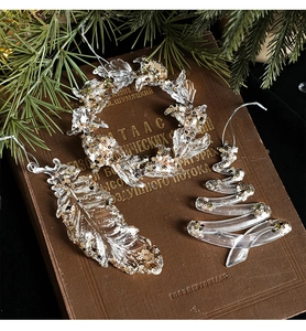 Clear acrylic Christmas ornaments with glitter on vintage book with pine branches