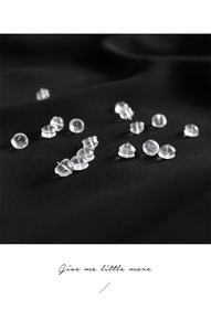Macro shot of soft transparent silicone earring backs scattered on dark fabric