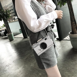 Vue détaillée du petit sac bandoulière argenté en forme d'appareil photo avec chaîne