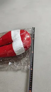Detail view of plush Christmas elf leg decoration being measured with a yellow tape rule