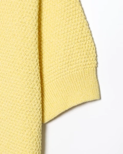 Vue détaillée de la robe en maille jaune avec texture côtelée et détails de finition