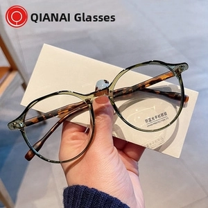 Dettaglio di occhiali anti-luce blu con montatura tonda verde e stanghette tartarugate