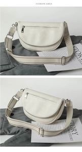 Detail of white crescent crossbody bag with adjustable wide strap and lychee grain texture