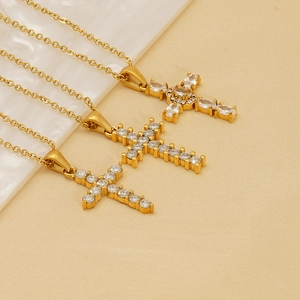 Three gold cross necklaces with cubic zirconia in a minimalist artistic arrangement