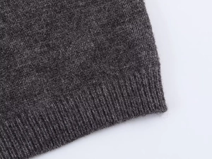 Macro shot of charcoal grey rib-knit hem texture on a casual fashion knit sweater