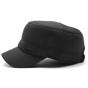 Detail of the side of a black flat top hat showing the men's metal logo and windproof fabric