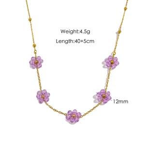 Baroque style gold beaded necklace with five purple stone flower pendants on white background