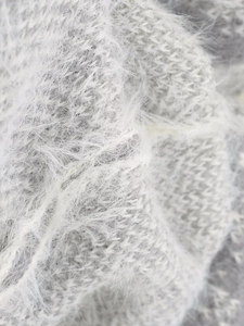 Macro view of white and grey fuzzy knit fabric with soft mohair texture details