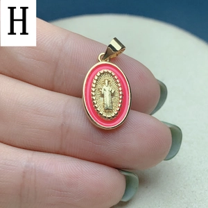 Detailed close-up of an oval gold religious pendant with pink enamel border and icons