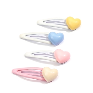 Cute heart-shaped children's hair clips in yellow, blue, pink and beige on white background
