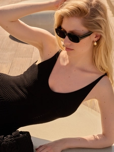 Close-up of black hollow-out knit dress showing V-neck and wave texture details