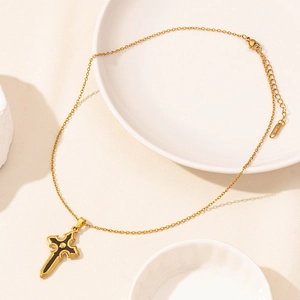 Macro shot of 18K gold plated stainless steel cross pendant with black enamel inlay
