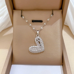 Detailed view of silver heart pendant with full zircon inlay on champagne velvet lining