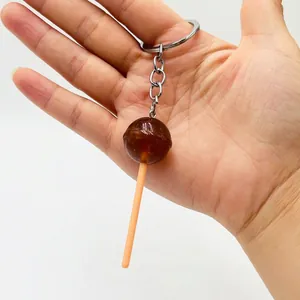 Detailed view of a dark brown resin lollipop keychain with a silver metal keyring