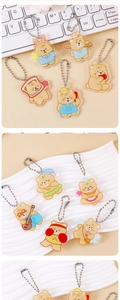Close-up of cute cream yellow acrylic bear keychains with various character themes