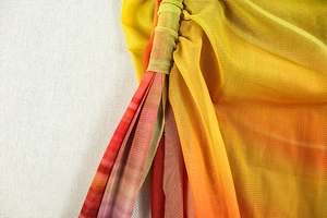 Detail of ruched mesh fabric featuring a warm yellow and red gradient color transition