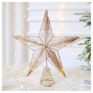 Macro detail of champagne gold Christmas tree topper with glitter and warm LED lights