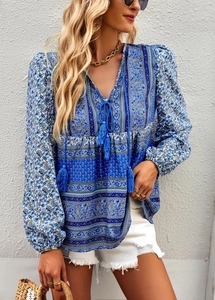 Close-up of blue bohemian V-neck blouse with tassel ties and contrast pattern design