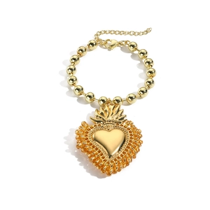 Detailansicht eines goldenen Sacred Heart Anhängers an einem Perlenarmband mit Karabinerverschluss