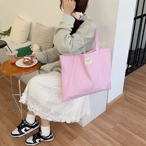 Pink striped canvas tote bag shown in a lifestyle setting for casual daily use