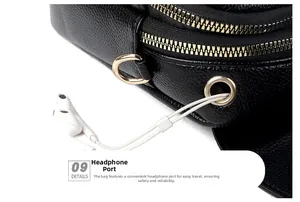Detail view of black lychee leather crossbody bag with dual zippers and gold earphone port
