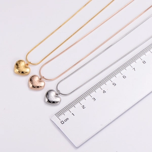 Detailed view of heart pendants on snake chains with size reference and love engraving