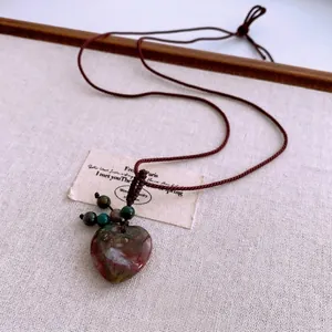 Vintage heart-shaped bloodstone pendant necklace on a brown woven cord for women