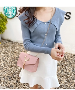 Close-up of pink crossbody bag featuring a gold metal deer head buckle and elegant tassel