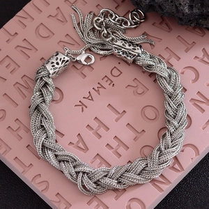 Bracelet torsadé argenté vintage avec breloques à pompons et fermoir homard sur roche