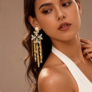 Detailed view of 18K gold-plated long tassel earrings with pearls and crystals on model