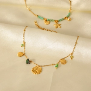Detail of 18K gold stainless steel shell and starfish bracelets on soft satin fabric